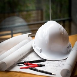 construction worker's cap and tools resting on table